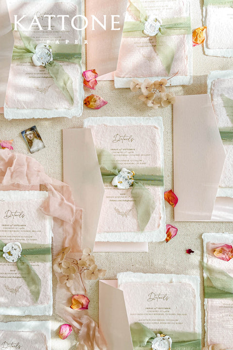 Elevate your wedding announcement with this exquisite invitation suite, meticulously crafted for a truly memorable impression. This set combines the luxurious, textured feel of handmade paper with the sophisticated details of premium silk ribbons and personalized wax seals. The entire suite is elegantly enclosed in beautiful coco linen petite pink envelopes, adding a final touch of charm and romance that your guests will adore from the moment they open their mail.