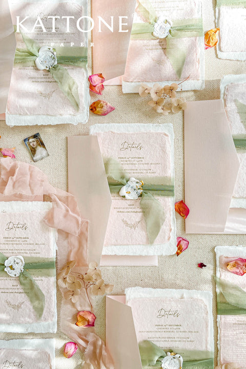 Elevate your wedding announcement with this exquisite invitation suite, meticulously crafted for a truly memorable impression. This set combines the luxurious, textured feel of handmade paper with the sophisticated details of premium silk ribbons and personalized wax seals. The entire suite is elegantly enclosed in beautiful coco linen petite pink envelopes, adding a final touch of charm and romance that your guests will adore from the moment they open their mail.