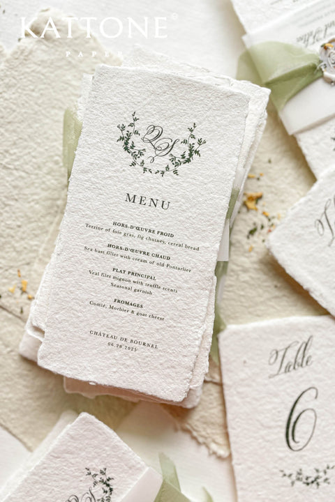 These handmade paper wedding menus are the epitome of timeless elegance and refined craftsmanship. Made from 100% cotton rag paper, each piece features a beautifully textured surface and natural deckled edges, exuding the charm of fine art stationery. The menu design showcases a botanical-inspired monogram delicately printed in deep green ink, creating a harmonious blend of organic beauty and understated luxury.