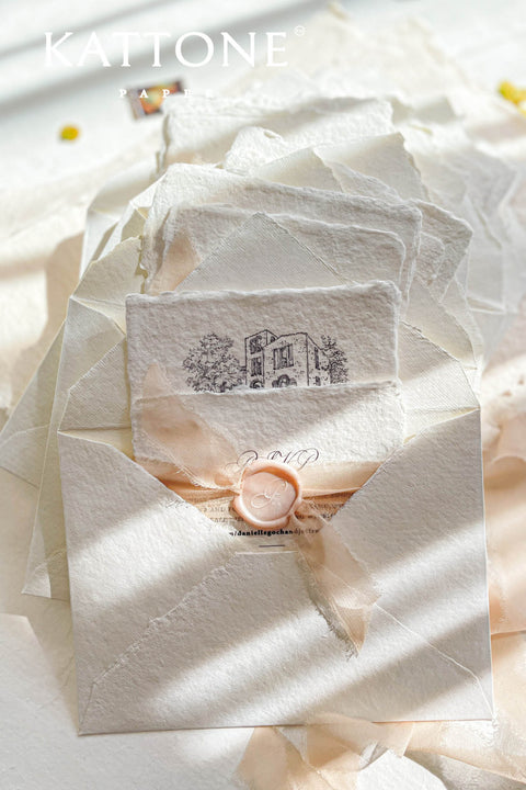 This exquisite handmade paper invitations suite offers a blend of fine artistry and personal romance. Each invitation is a true work of art, featuring a custom, hand drawn wedding venue illustration that beautifully captures the unique charm of your location. The luxurious, textured paper and timeless design create a truly romantic wedding stationery set that will be cherished by your guests long after your special day.
