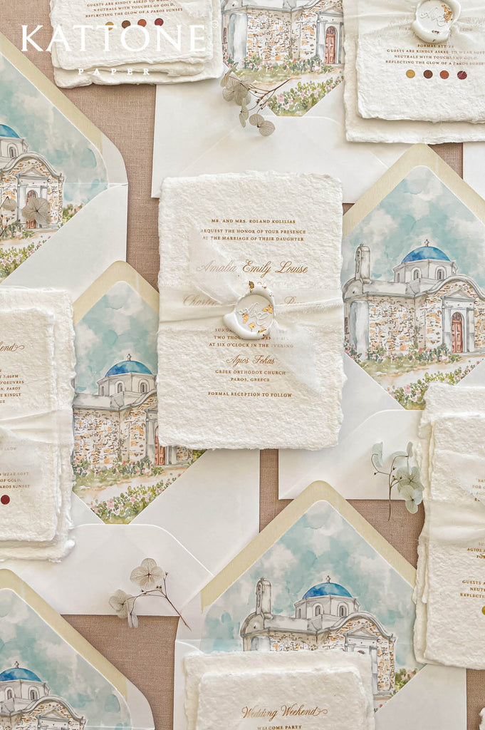 Fine art wedding invitation suite styled in a flat lay with handmade paper invitations, inserts, envelopes and watercolor liners.
