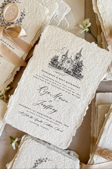 Close-up of handmade cotton paper wedding invitation featuring an illustrated church venue and elegant calligraphy.