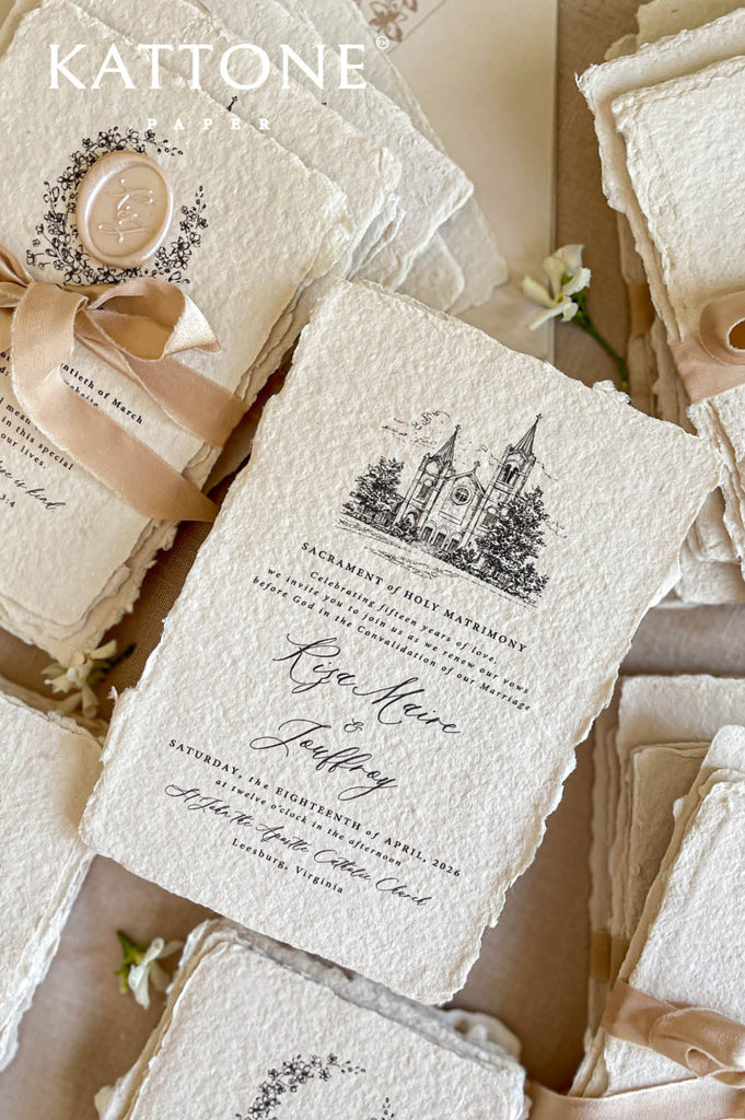 Close-up of handmade cotton paper wedding invitation featuring an illustrated church venue and elegant calligraphy.