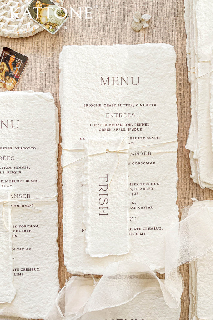 Elegant handmade paper wedding menu featuring clean editorial typography and naturally deckled edges for a refined luxury tablescape.