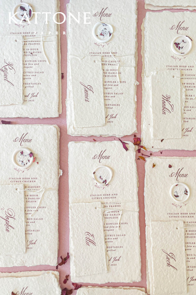 Luxury wedding menu on handmade paper featuring wax seal accent and soft neutral color palette.