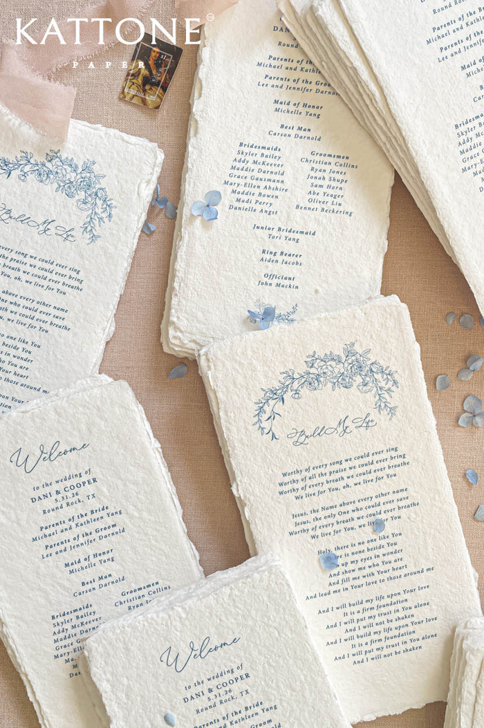 Luxury handmade paper wedding program featuring deckled edge cotton paper, blue floral artwork, and elegant typography.