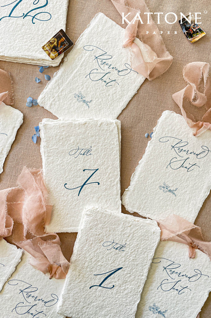 Luxury handmade paper table number card with elegant typography designed for sophisticated wedding reception styling.
