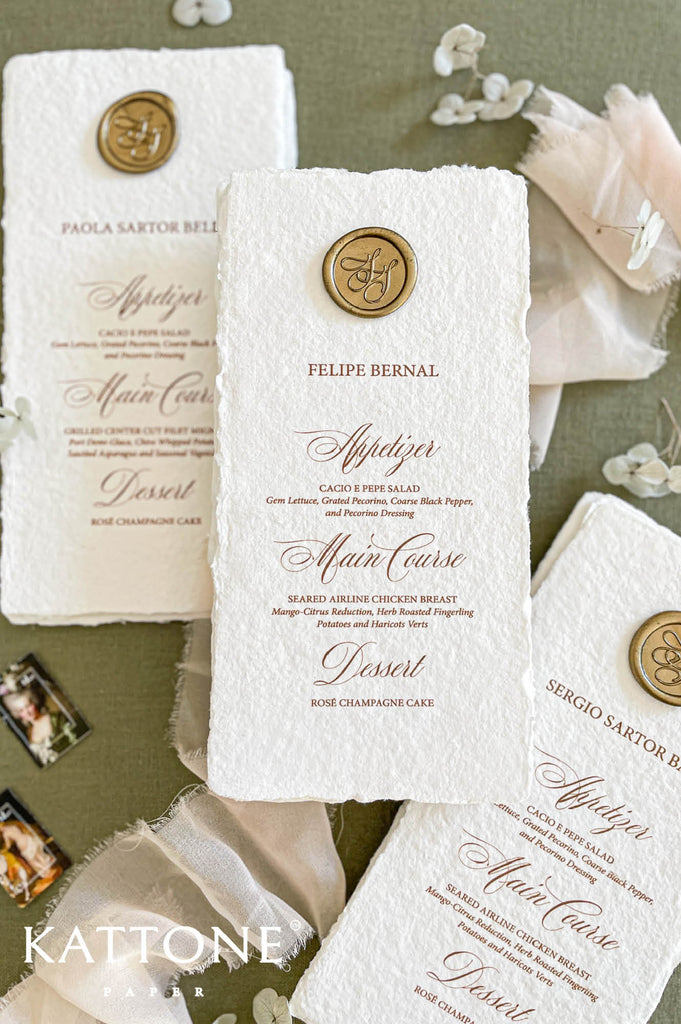 Set of handmade wedding menus arranged together showcasing cohesive design, wax seal accents and elegant typography.