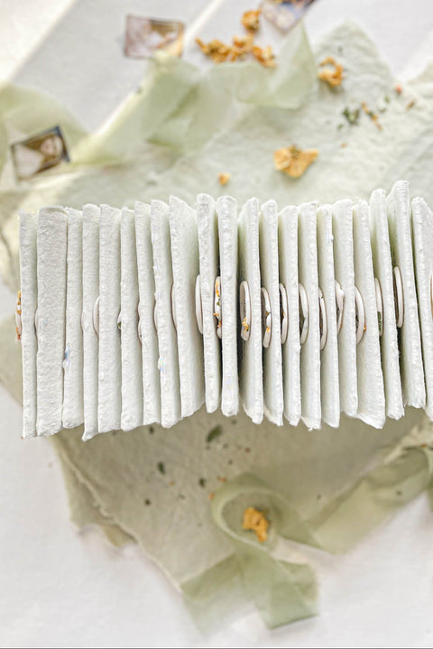 Elevate your table setting with our fine-art handmade paper place cards, each adorned with an elegant pressed-flower wax seal and delicate botanical artwork. Crafted from luxury deckled-edge cotton paper, these name cards bring a romantic, organic charm to weddings, garden celebrations, and intimate events. Their soft sage tones and artisanal texture create an unforgettable, heirloom-quality detail for your guests.