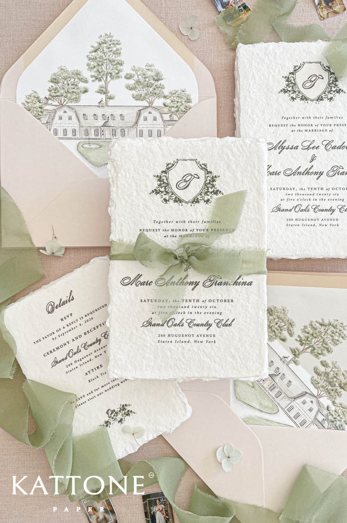 Luxury handmade paper wedding invitation suite with sage chiffon ribbon, botanical crest monogram and blush envelopes with custom venue illustration liners.