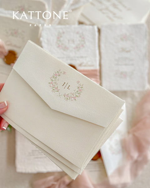 Announce your special day with the delicate, romantic charm of these handmade wedding invites. Perfect for a summer wedding, this suite features a soft and beautiful dusty pink color palette and delicate floral artwork. Each invitation is individually crafted, giving it a unique, tactile feel that you and your guests will appreciate. The combination of handcrafted artistry and a fresh, romantic design sets a beautiful tone for your celebration.