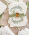 Luxury handmade cotton paper wedding invitation with deckled edges and botanical wreath, styled with sage silk ribbon, wax seal and coordinated stationery suite on neutral linen background.