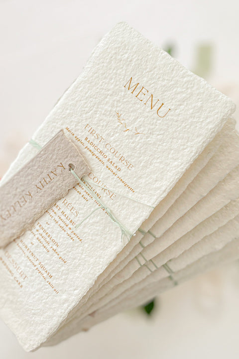 Add refined sophistication to your tablescape with our handmade paper wedding menus with personalized name tags - a perfect fusion of artisanal texture and elegant design. Each piece is hand-torn from luxury cotton paper, featuring deckled edges, fine typography, and customizable tags tied with delicate thread. These menus create a cohesive, fine-art look while doubling as elegant place cards for your guests.