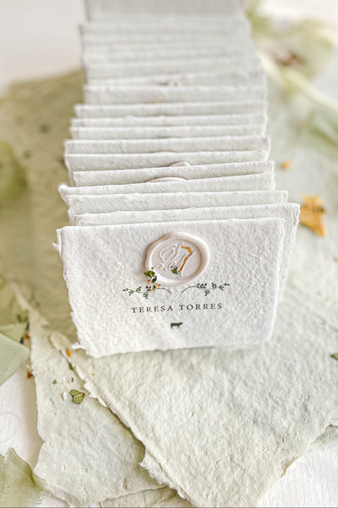 Elevate your table setting with our fine-art handmade paper place cards, each adorned with an elegant pressed-flower wax seal and delicate botanical artwork. Crafted from luxury deckled-edge cotton paper, these name cards bring a romantic, organic charm to weddings, garden celebrations, and intimate events. Their soft sage tones and artisanal texture create an unforgettable, heirloom-quality detail for your guests.