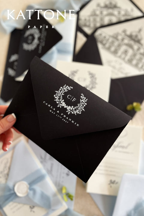 Close-up of white ink address printing on black envelope showing crisp lettering and refined contrast against matte cardstock.
