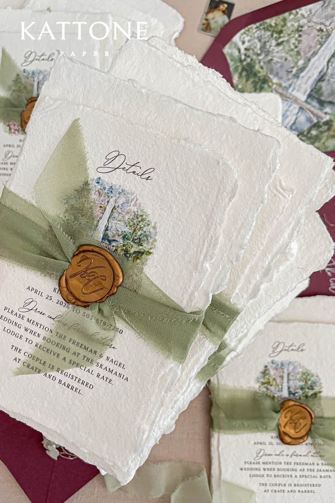 Hand-torn sage green silk ribbon wrapped around handmade wedding invitation secured with decorative wax seal.