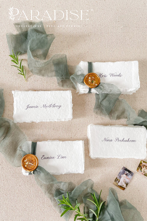 Enhance your tablescape with our handmade paper place cards, crafted from luxurious cotton rag paper and finished with naturally torn deckled edges. Each card features elegant calligraphy, soft hand-dyed ribbon, and the option of a wax seal for added fine-art charm. Perfect for weddings, engagement parties, showers, and upscale events, these artisanal place cards bring texture, romance, and sophistication to every setting.