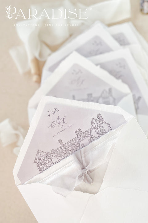 Handmade paper envelopes with hand-drawn envelope liners styled with silk ribbon, soft lighting, and fine art wedding stationery details.