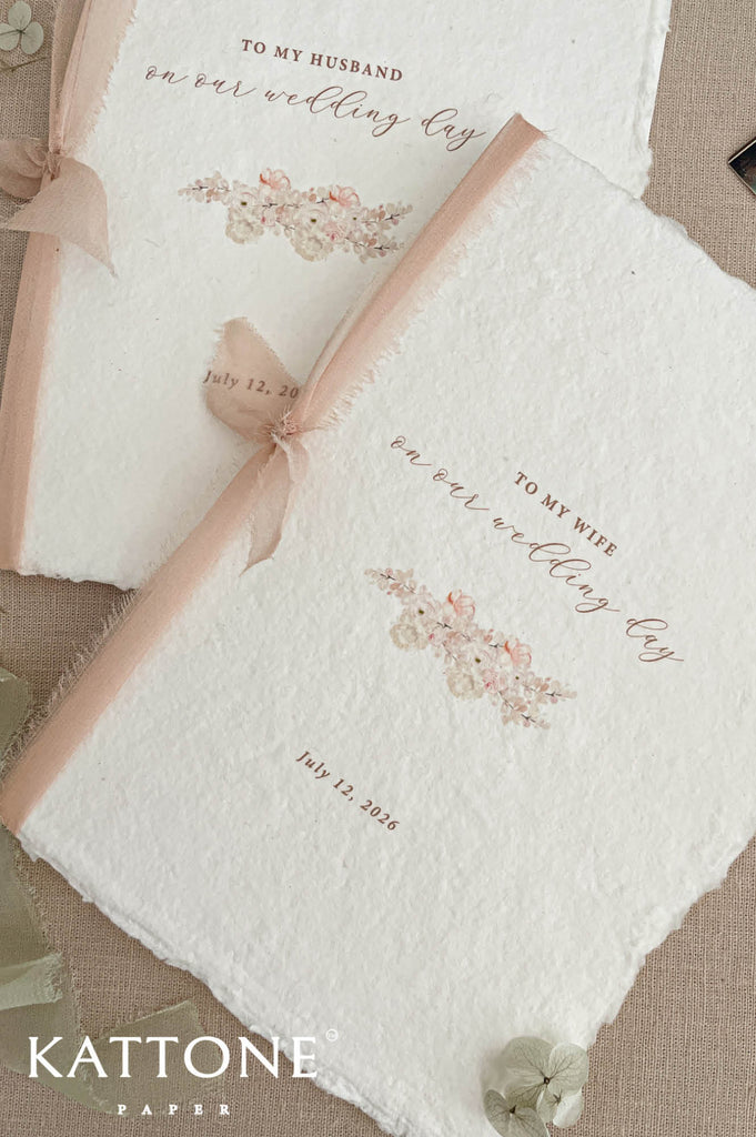 Close up of cotton paper wedding program showing textured surface, deckled edges and soft ribbon detail.