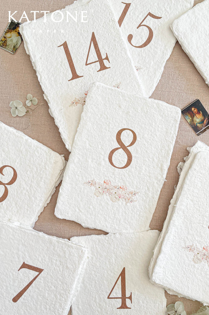 Close up of handmade deckled edge paper showing natural fibers and soft organic texture for luxury wedding stationery.