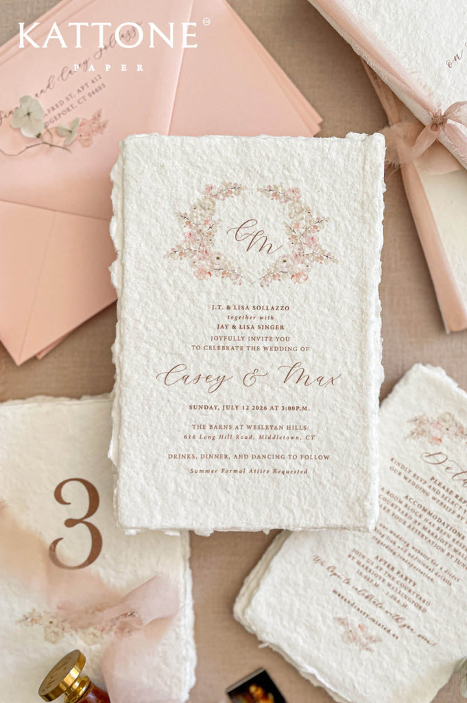 Fine art wedding invitation suite arranged in a flat lay with handmade paper invitations, RSVP and details cards, envelopes and ribbon accents.