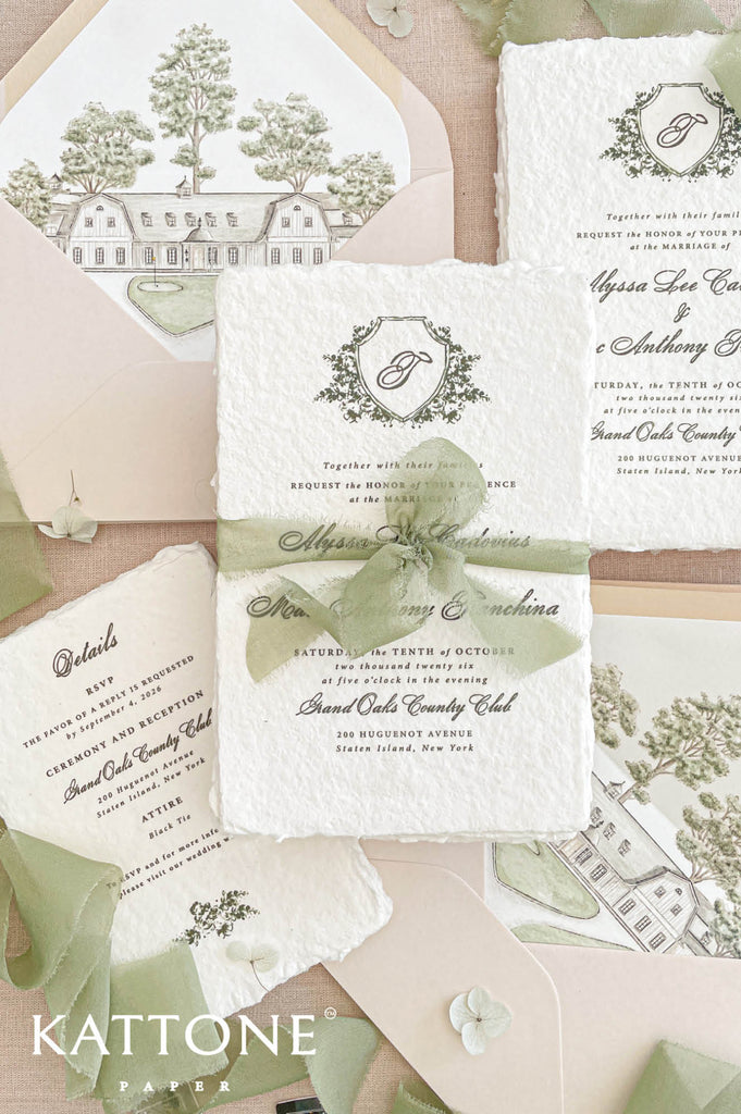 Premium handmade wedding invitation suite with custom venue artwork, deckled edge cotton paper, blush envelopes, botanical crest details, and soft sage green ribbon accents for elegant estate or garden weddings.