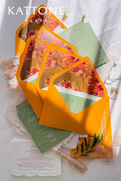 Stack of terracotta envelopes with floral liners visible, highlighting warm tones, consistent artwork, and luxury stationery quality.