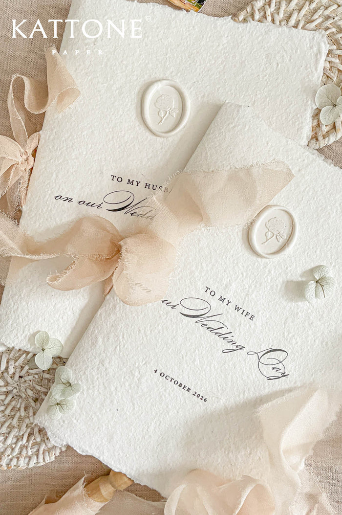 Luxury handmade paper wedding vows booklet featuring deckled edge cotton paper, elegant typography, chiffon ribbon ties, and wax seal accents.