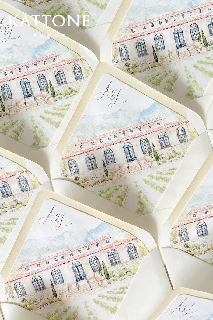 Luxury ivory wedding envelopes with custom watercolor venue liners featuring a romantic estate illustration in soft blue, cream, and green tones.