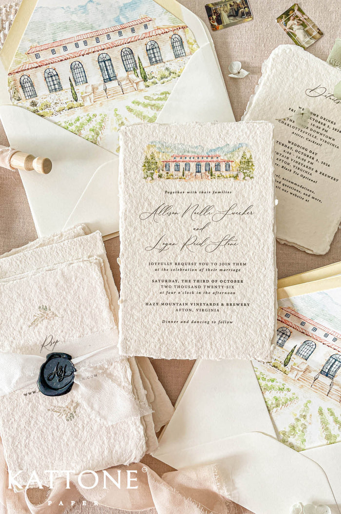 Luxury handmade paper wedding invitation suite featuring deckled-edge cotton paper, custom venue artwork, ivory envelopes, chiffon ribbon, and wax seal styling.
