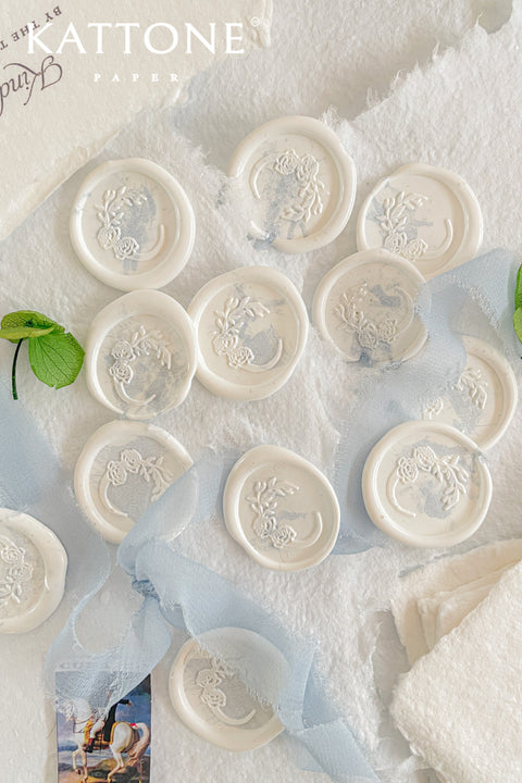 Hand-poured wax seals designed to add a soft, romantic finish to wedding stationery, envelopes, and heirloom keepsakes. Featuring an intricate floral crest pressed into creamy white wax, each seal offers timeless elegance with a tactile, artisanal feel. Perfect for couples seeking refined details that elevate their invitations, vows, or correspondence into something truly memorable.