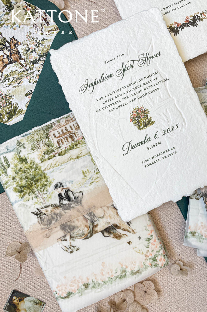 Close-up of embossed handmade paper wedding invitation showing watercolor artwork, textured cotton paper, and fine embossing.