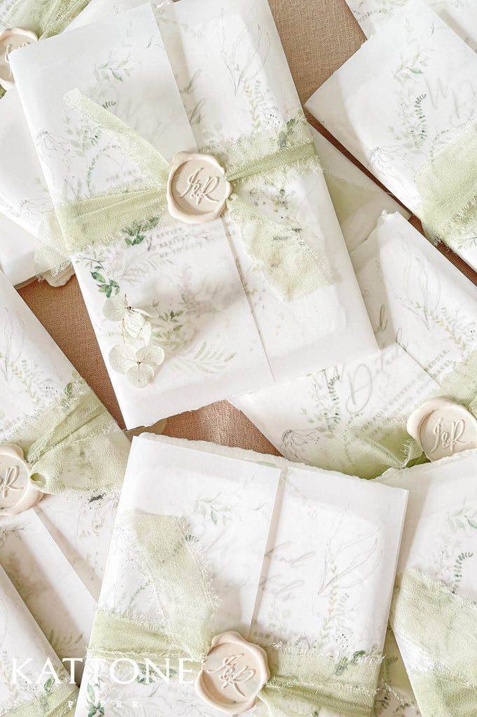 Soft translucent vellum jacket layered over the invitation creates a romantic and sophisticated presentation with subtle depth.