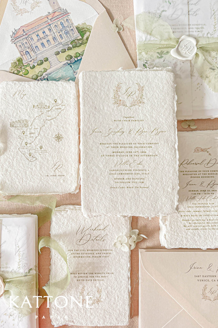 Luxury handmade paper wedding invitation suite featuring deckled edge cotton paper, custom watercolor venue artwork, vellum wraps, sage chiffon ribbon, personalized wax seals, and coordinating inserts in soft neutral tones.