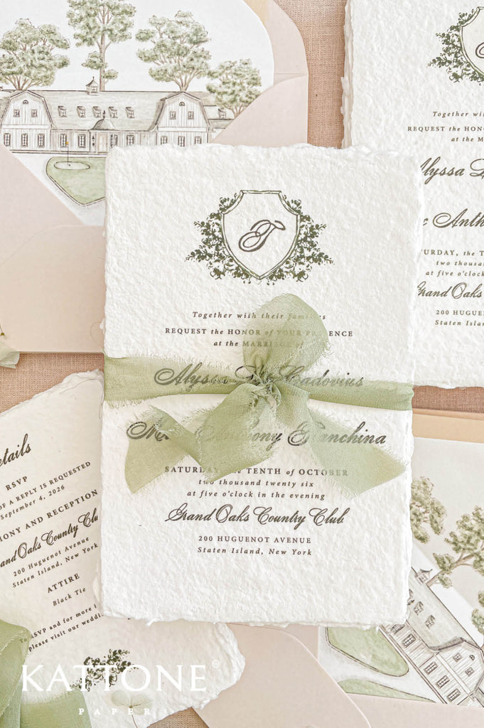 Luxury wedding invitation featuring a personalized botanical crest monogram with delicate greenery artwork, paired with timeless serif and script typography for a refined classic aesthetic.
