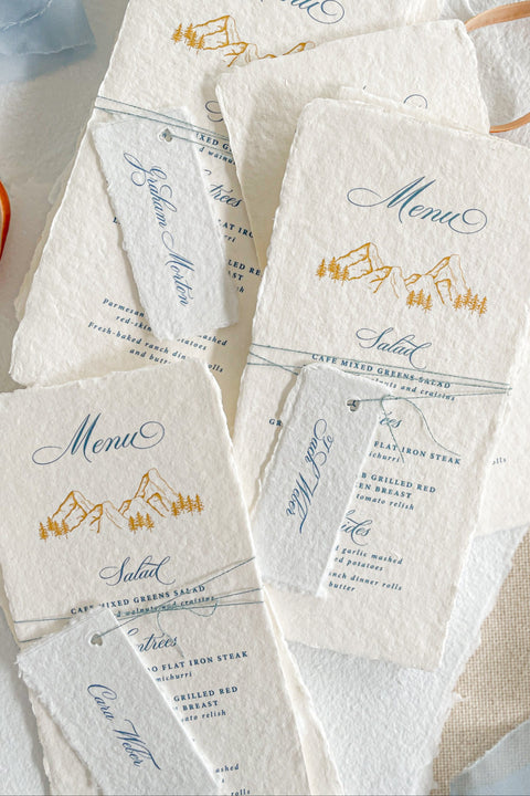 Capture timeless mountain charm with our handmade paper wedding menus, featuring soft deckled edges, textured cotton paper, and elegant alpine illustrations. Each piece is hand-pressed with artisanal care, pairing nature-inspired design with fine typography for an effortlessly elevated tablescape. Perfect for destination, outdoor, or rustic-elegant weddings, these menus bring natural sophistication to every detail.