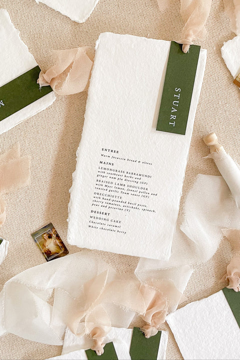 Make every seat a statement with our handmade paper wedding menus, featuring personalized name tags, soft ribbons, and deckled edges. Each menu is crafted on luxury cotton rag paper for a fine art look that’s both organic and sophisticated - ideal for modern, romantic, or nature-inspired weddings. Thoughtfully designed to blend function and beauty, these menus elevate your reception with artisanal charm and timeless elegance.