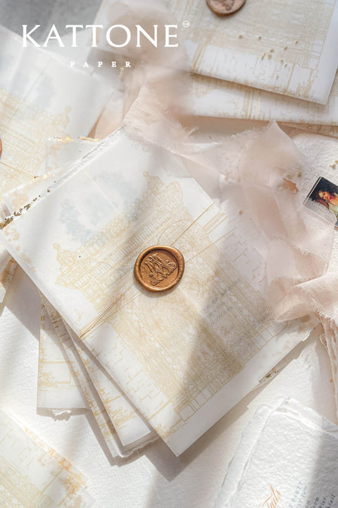 This handmade paper wedding invitation suite combines fine craftsmanship with opulent detailing. Printed on luxury cotton paper with deckled edges, each invitation is accented with subtle touches of gold leaf, catching the light with a refined shimmer that speaks of romance and sophistication. The design features a hand-painted floral monogram, symbolizing the couple’s union, surrounded by soft watercolor greenery and pastel hues.