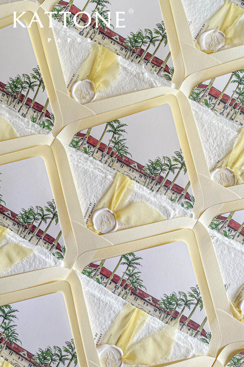 Close-up of watercolor venue illustration inside soft yellow envelope showing architectural details, soft washes, and refined paper texture.