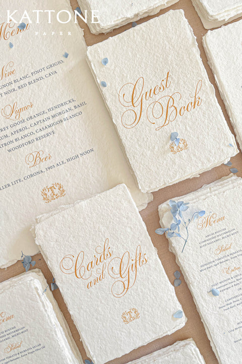 Elegant flat lay of luxury reception stationery showcasing handmade paper menus, refined typography, floral styling, and elevated presentation.