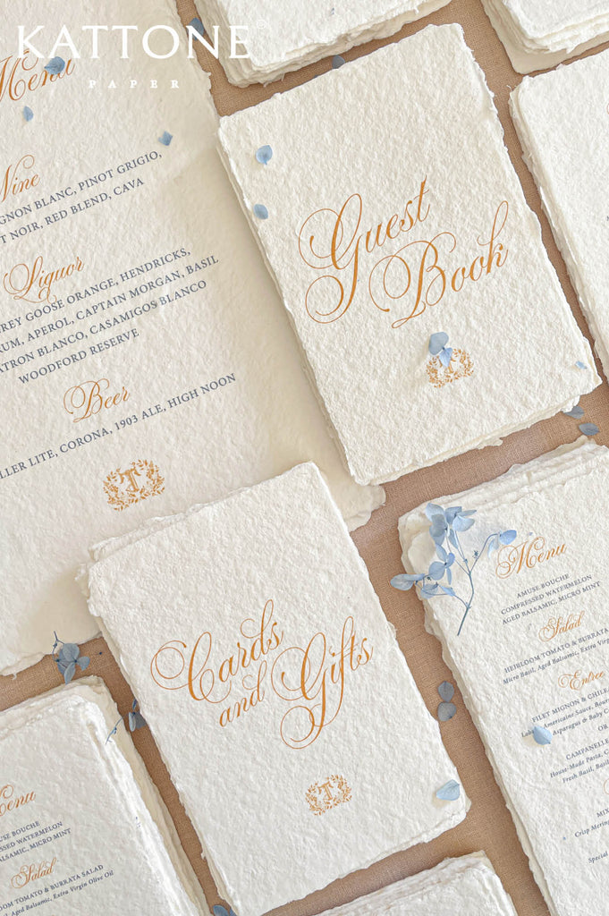 Elegant flat lay of luxury reception stationery showcasing handmade paper menus, refined typography, floral styling, and elevated presentation.