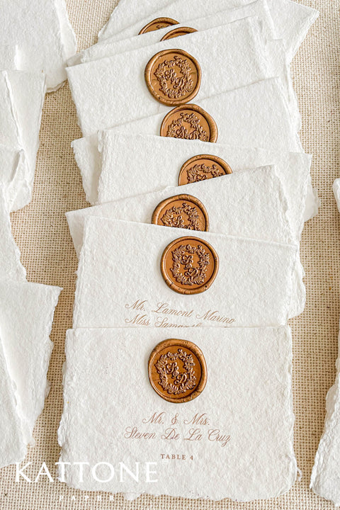 Create an elegant, heirloom-inspired tablescape with our handmade paper place cards, each finished with a luxurious bronze wax seal and finely printed guest names. Crafted from artisan deckled-edge cotton paper, these wedding place cards add a refined, old-world charm to any celebration. Perfect for classic, vintage, or fine-art events where every detail matters.