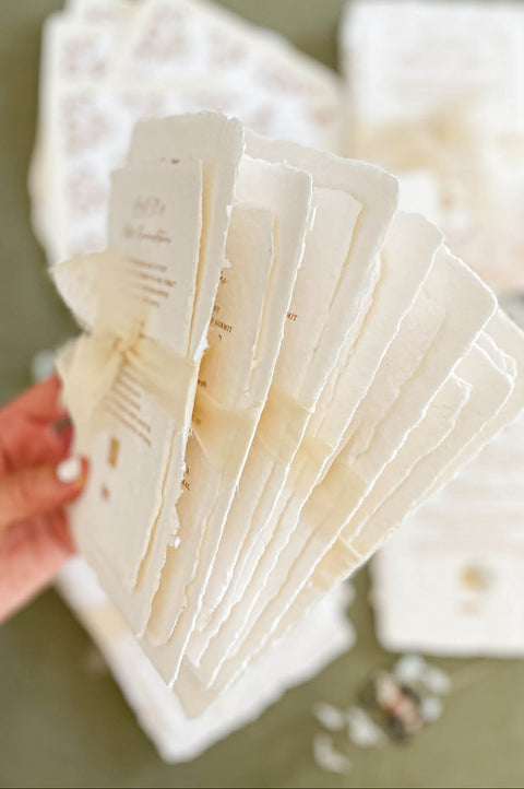 Handmade cotton paper with visible fibers and organically torn deckled edges highlighting artisanal craftsmanship.