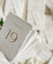 Handmade cotton paper and elegant gold typography come together to create a timeless table number design that elevates any fine-art wedding aesthetic. The soft deckle edges and organic texture introduce an artisanal touch, while the clean layout ensures clarity and sophistication. Perfect for couples who value quality, romance, and elegant minimalism, this design adds luxury and intention to every reception table.