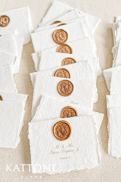 Create an elegant, heirloom-inspired tablescape with our handmade paper place cards, each finished with a luxurious bronze wax seal and finely printed guest names. Crafted from artisan deckled-edge cotton paper, these wedding place cards add a refined, old-world charm to any celebration. Perfect for classic, vintage, or fine-art events where every detail matters.