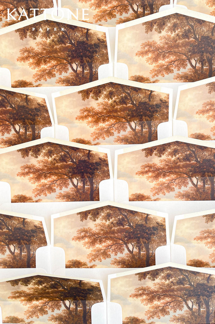 Luxury ivory wedding envelopes with custom fine art liners featuring romantic landscape artwork in warm autumn tones.