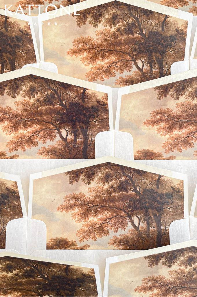 Wedding envelopes arranged in a flat lay showcasing custom fine art envelope liners with romantic landscape artwork.