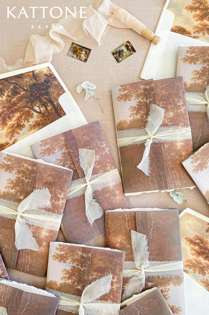 Soft translucent vellum wrap printed with scenic landscape artwork adds layering, depth, and elevated presentation.