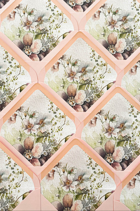 Blush pink wedding envelopes with botanical watercolor envelope liners featuring delicate floral illustrations and soft greenery.