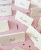 Handmade paper wedding place cards with deckled edges and calligraphy guest names, fine art table styling on blush linen.
